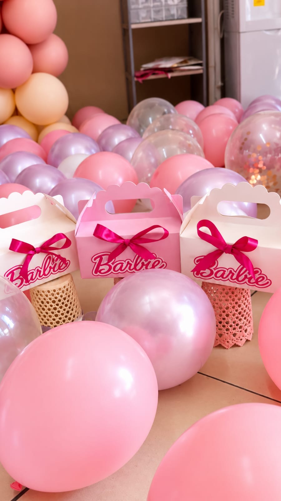 Barbie themed party setup with pink balloons and treat boxes