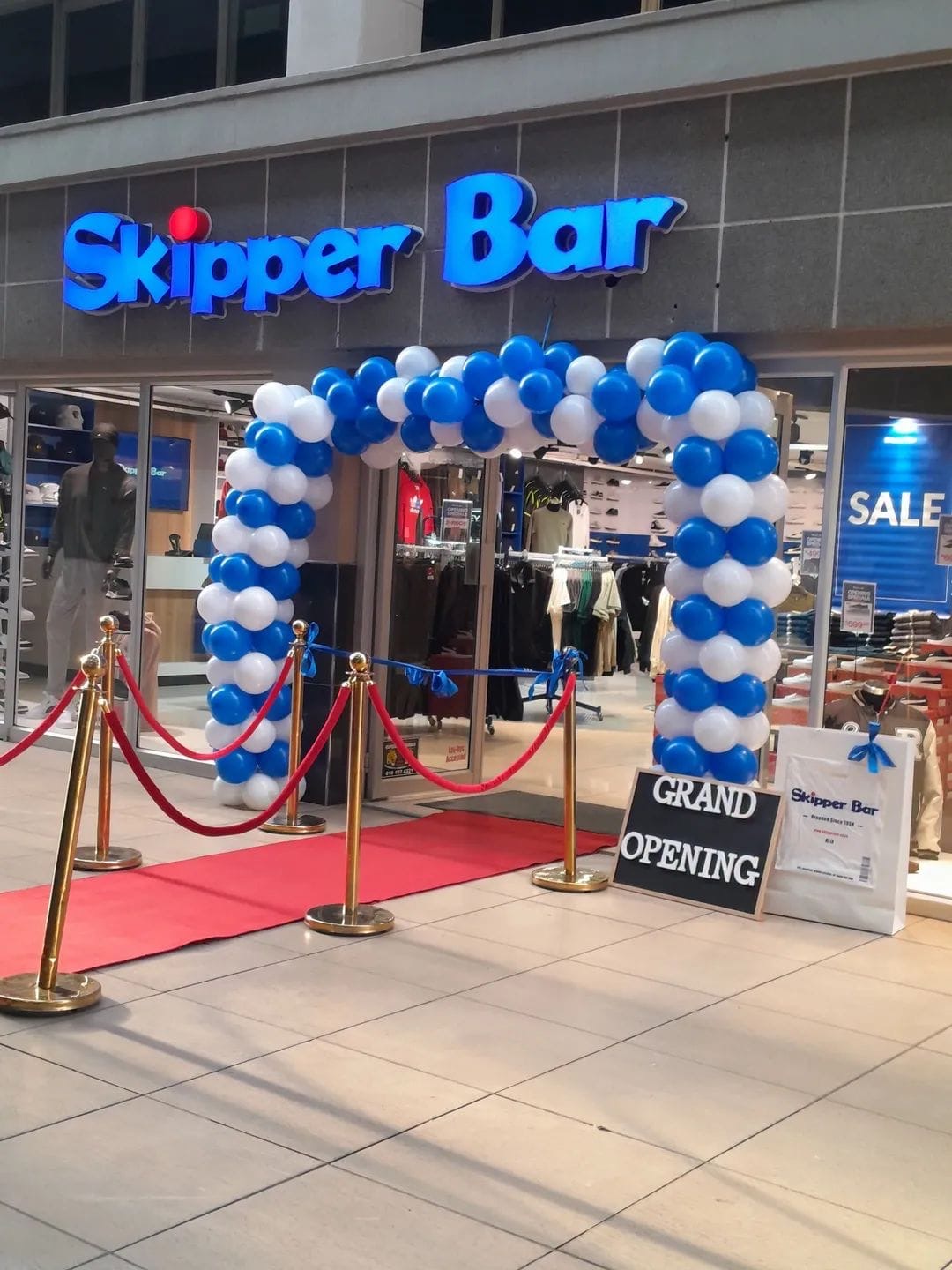 Blue and white balloon arch for a store grand opening