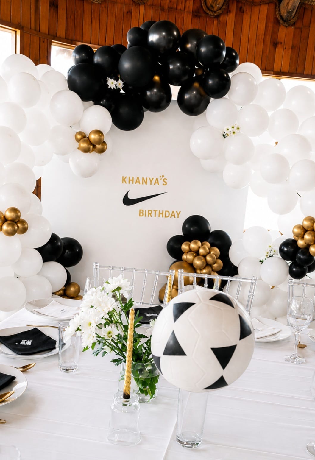 Black, white and gold balloon arch party styling